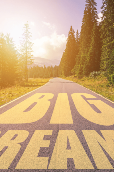 a picture of mountains and trees and the words big dreams written on the road.